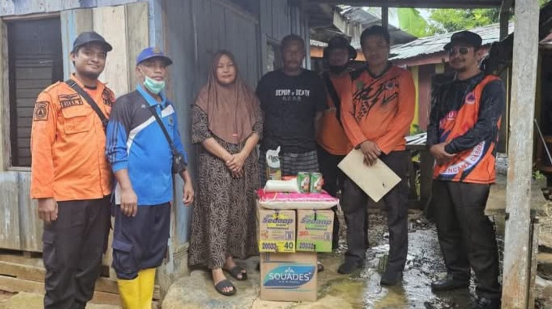 PENYERAHAN BANTUAN. Petugas BPBD PPU mengantarkan bantuan kepada salah satu keluarga bencana rumah ambruk di Kelurahan Maridan, Kecamatan Sepaku, Minggu (22/3/2025).