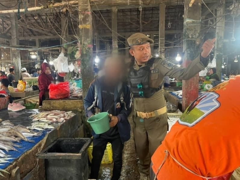 MERESAHKAN. Petugas Satpol PP PPU mengamankan seorang pengamen di Pasar Induk Penajam.