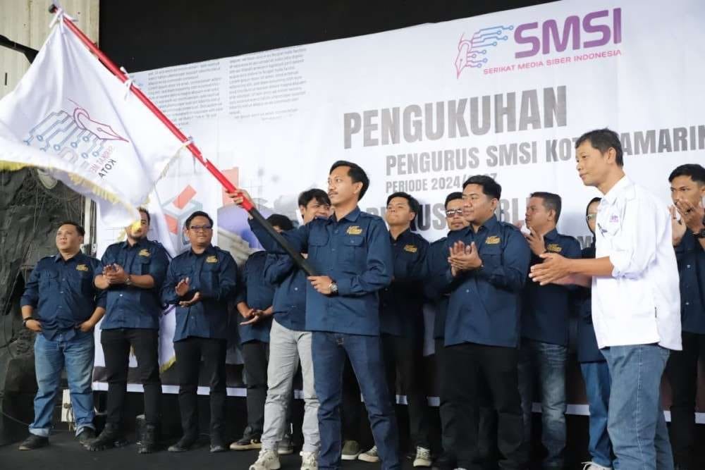 KEKOMPAKAN. Arditya Abdul Aziz, mengibarkan bendera organisasi usai terpilih menjadi ketua SMSI Kota Samarinda.
